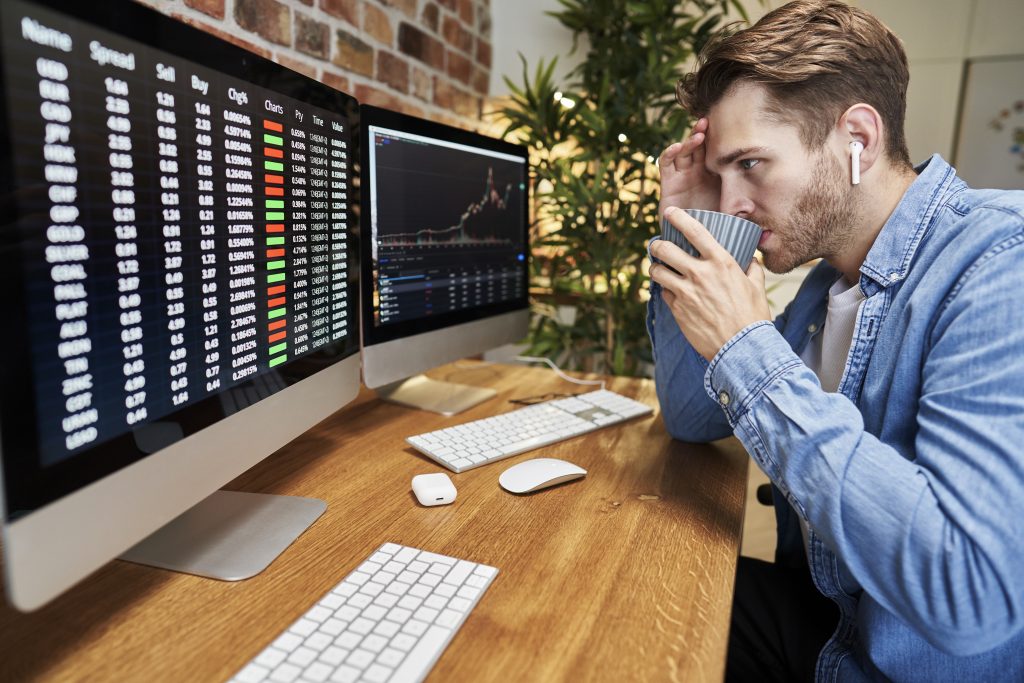 Adult man following stock market data on screen