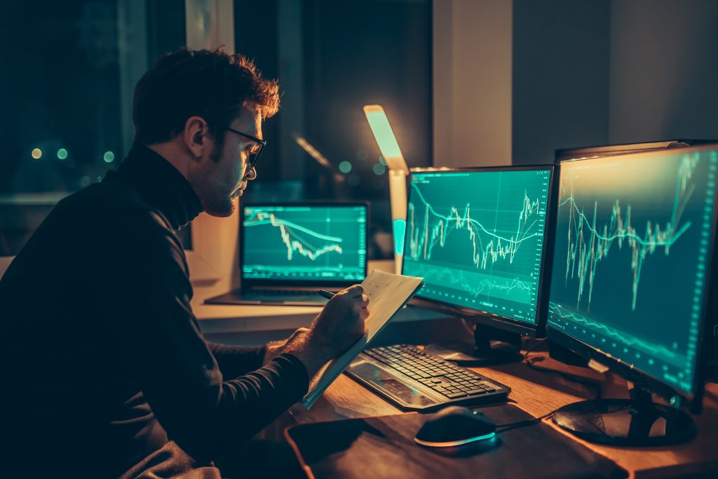 Trader analysing stock market data at night